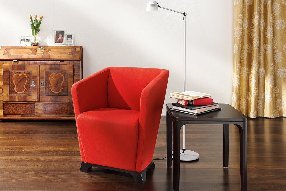 kleine fauteuil met rode stoffering en houten poten