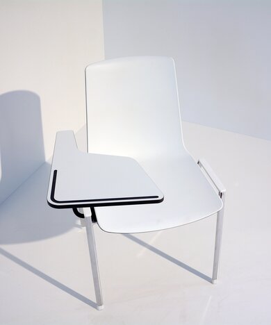 witte zaalstoel met koppelsysteem conform EN 14703 met een gemonteerd opklapbaar schrijfblad
