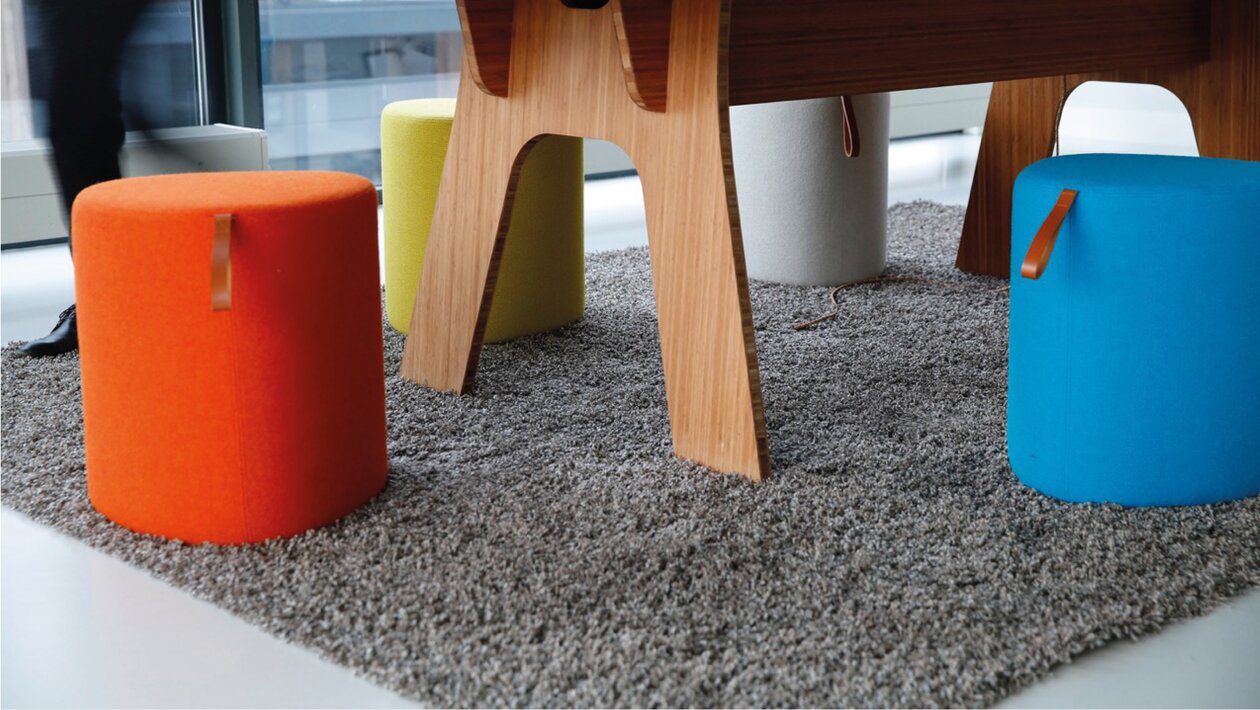 Colourful poufs in front of a table.
