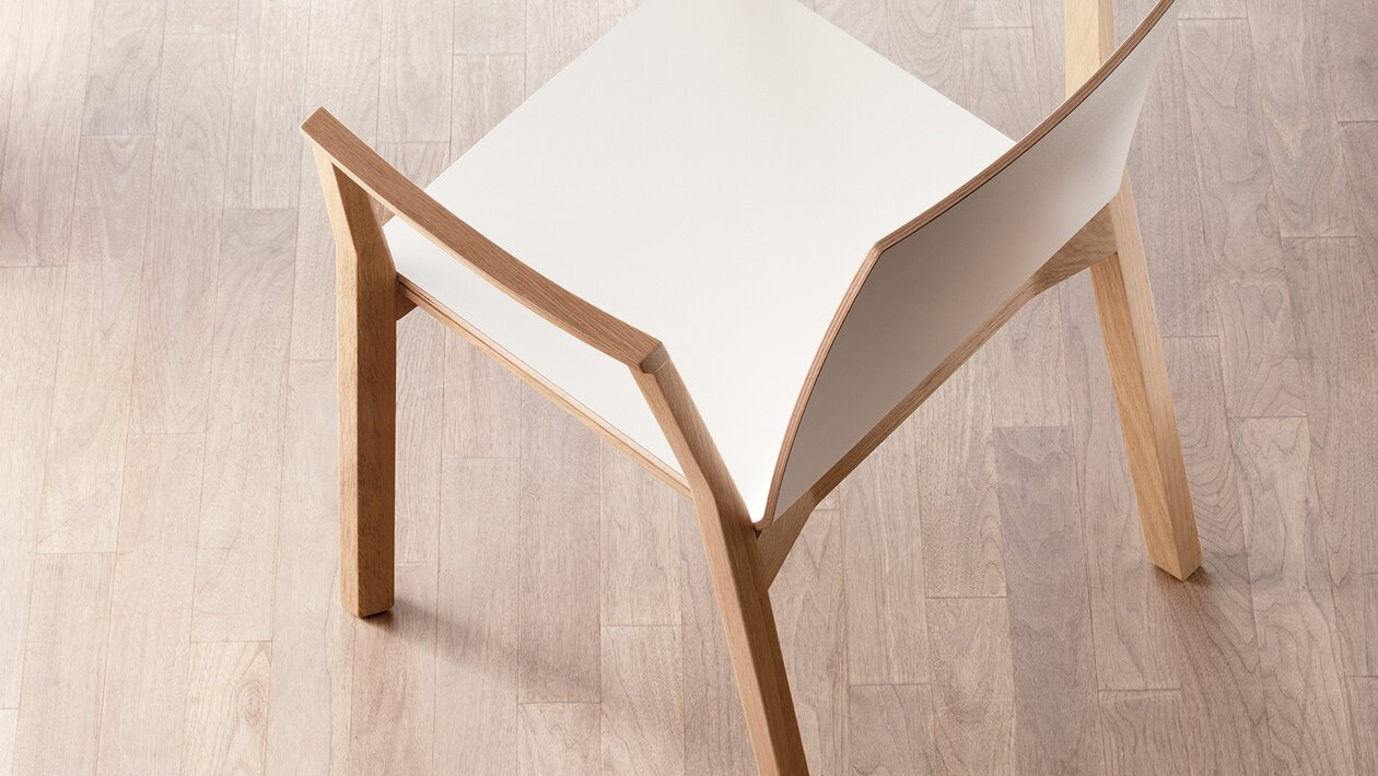 stapelbare houten stoel met armleuningen en witte zitschaal, van bovenaf gezien