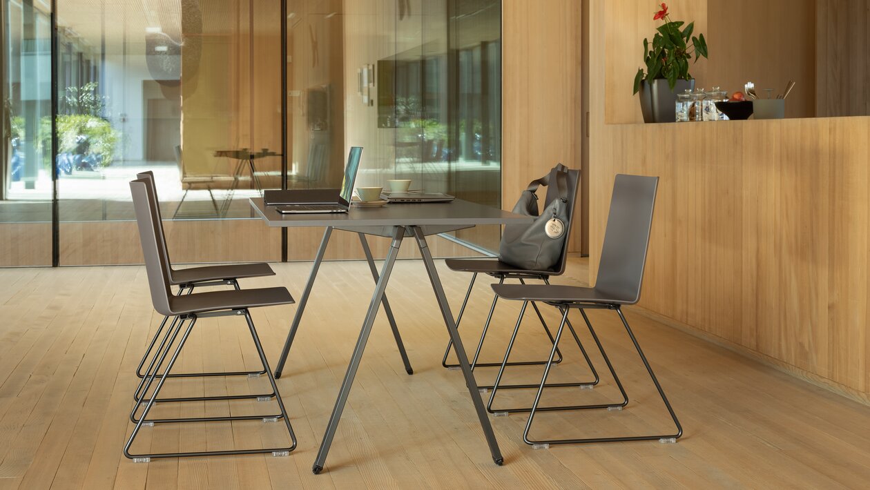 chaises en fil noir placées sur une table rectangulaire noire