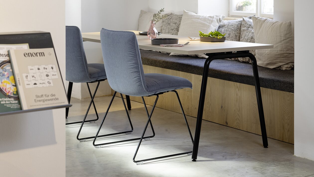 Two blue padded skid base chairs in a restaurant.