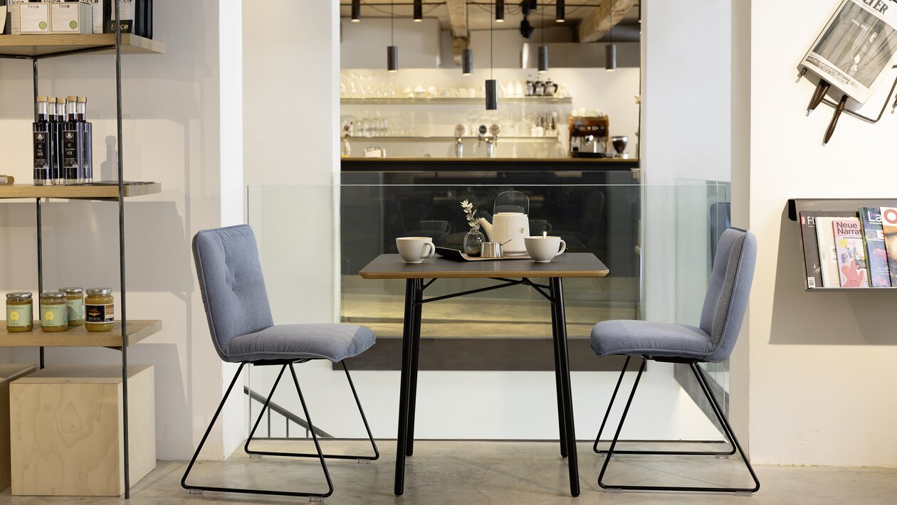 Restaurant with two blue padded skid-base chairs.