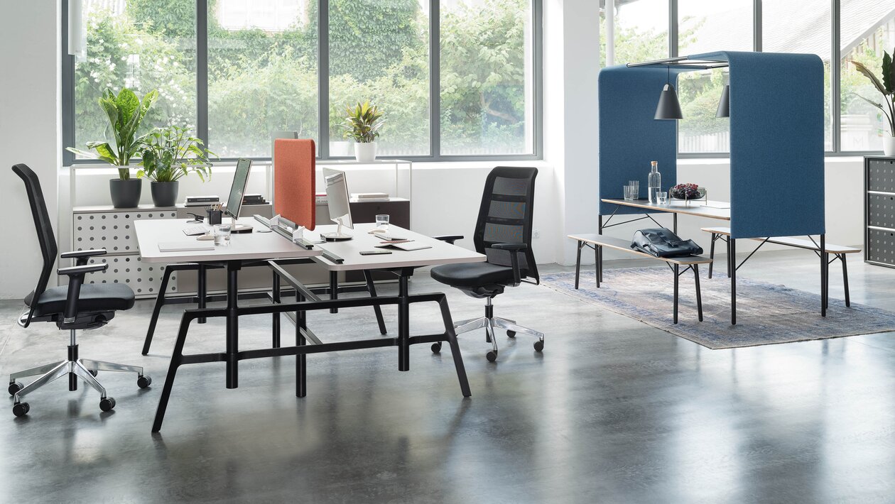 Office desk with black swivel chairs in a light and modern office.