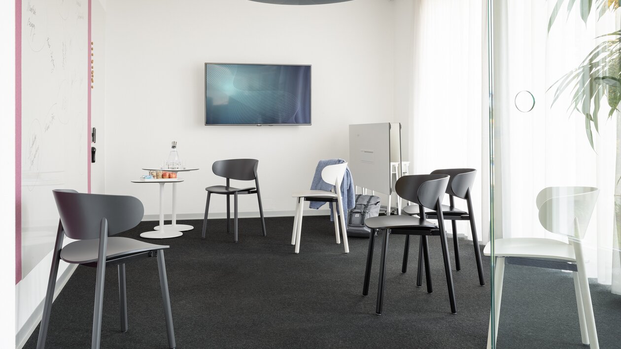 Different wooden chairs in a meeting room.