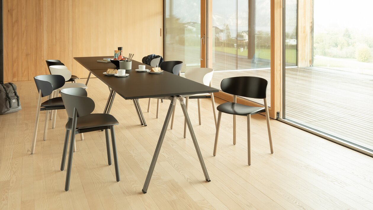 Different wooden chairs in a meeting room with a wooden floor. 