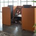 Person sitting at a table, surrounded by orange screens.