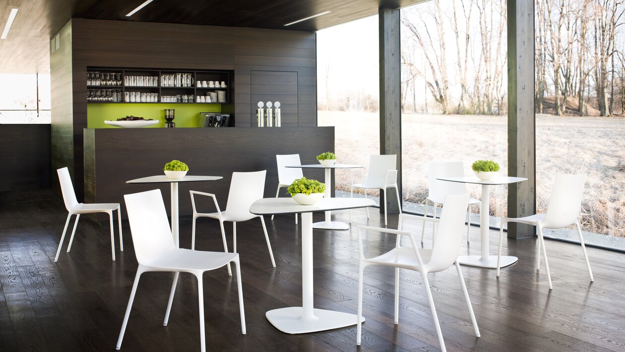 White chairs with white bistro tables at a café.