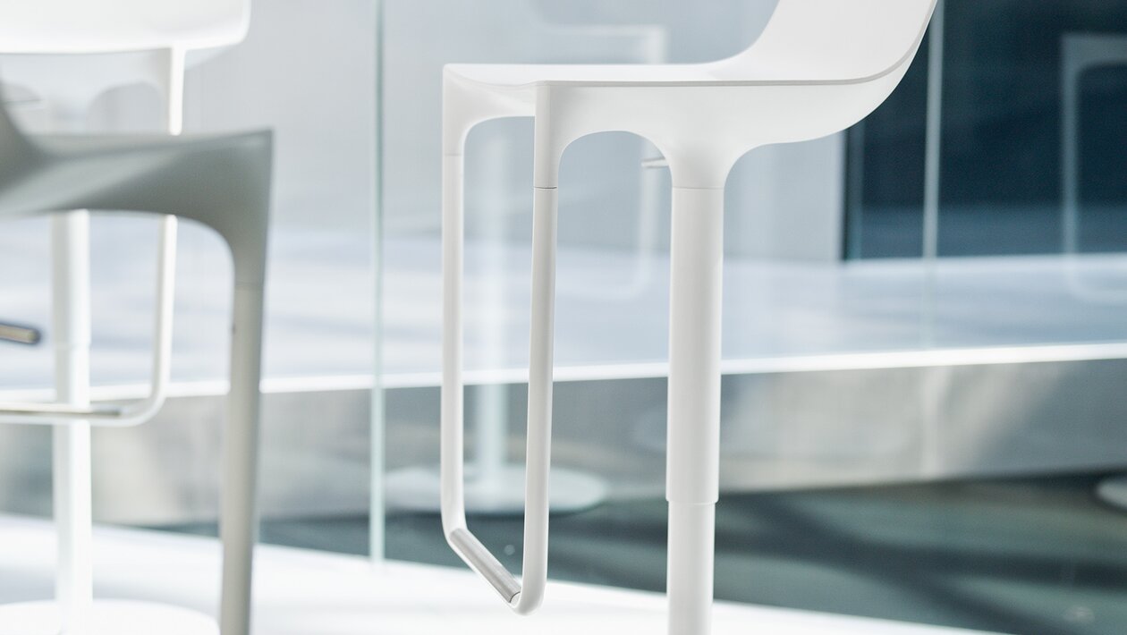 tabouret de bar blanc moderne sur pied de colonne devant une fenêtre