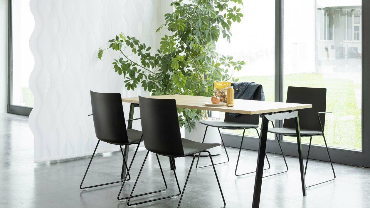 Folding table with four black skid-base chairs.