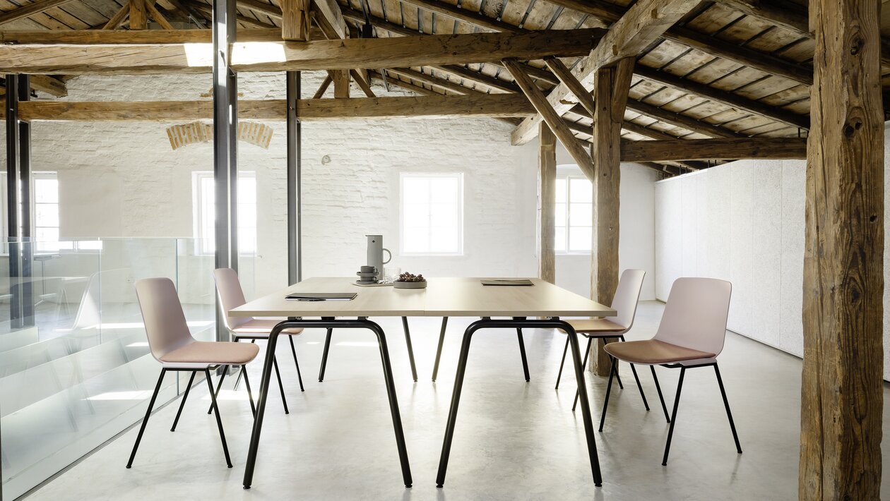 Folding table with four rose stacking chairs.