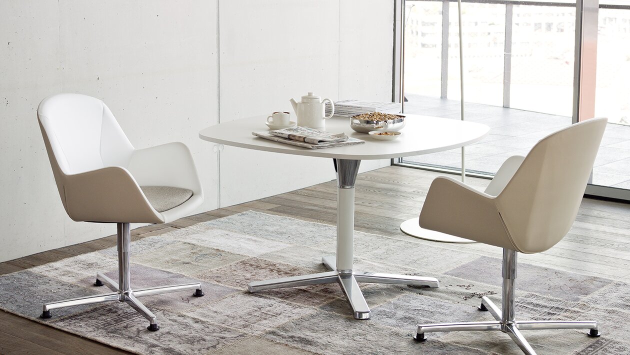 Two white conference chairs at a white table.