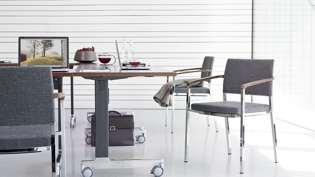 chaises de conférence avec revêtement tissu gris à une table pliante sur roulettes