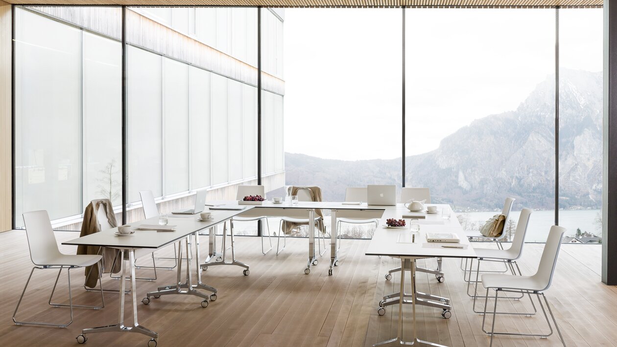 Flipflop tables at a meeting room with white skid base chairs.