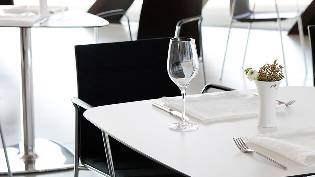 vue détaillée d'un bistro avec chaises noires avec accoudoirs et tables