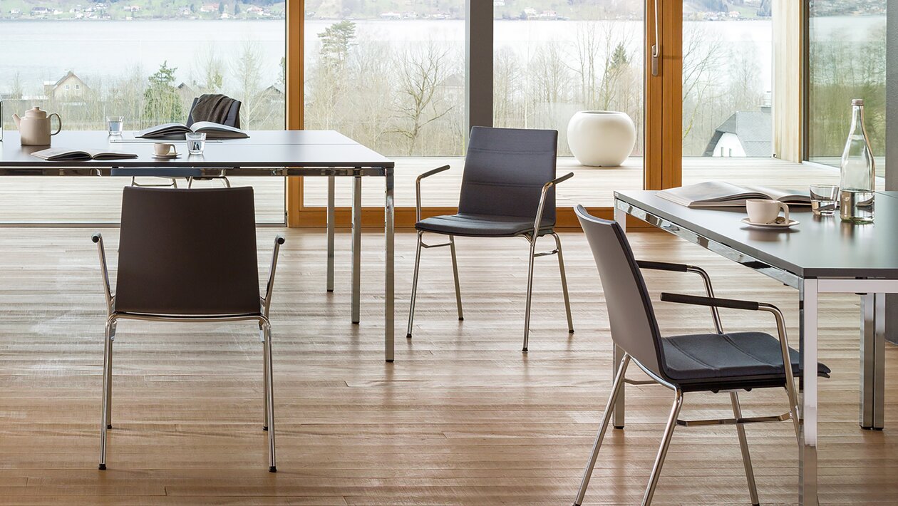 découpe d'une salle de réunion avec chaises noires et tables noires