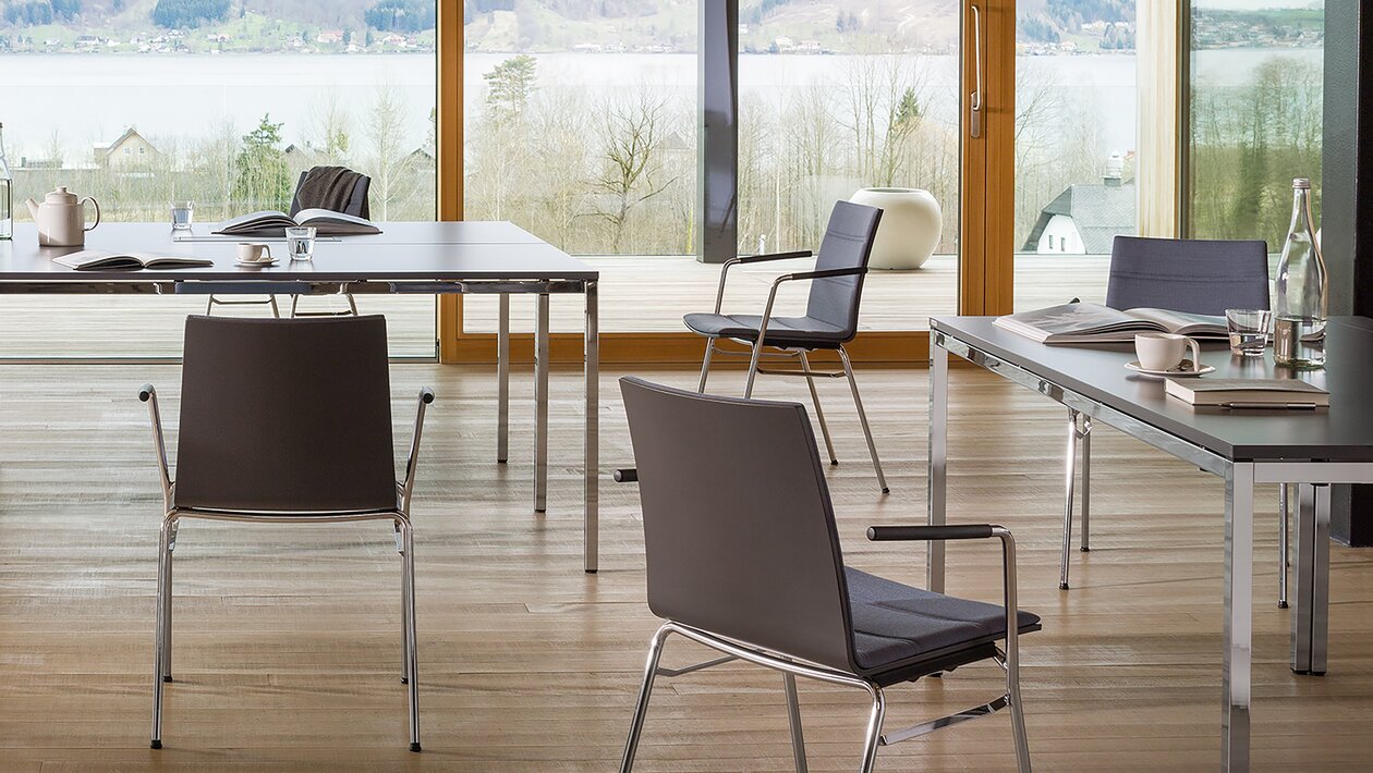 découpe d'une salle de réunion avec chaises noires et tables noires