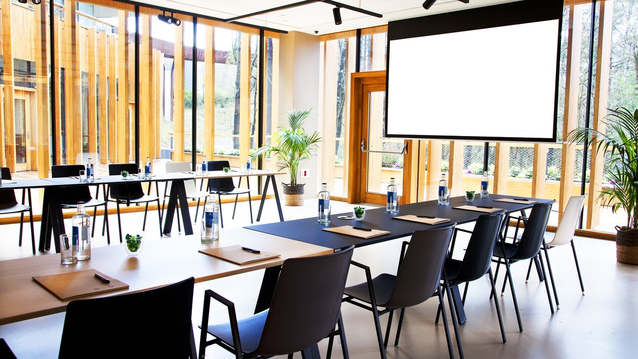 Black tables with black chairs in a conference room.