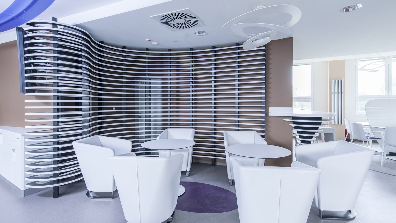 White lounge seating and white bistro tables in a working café.