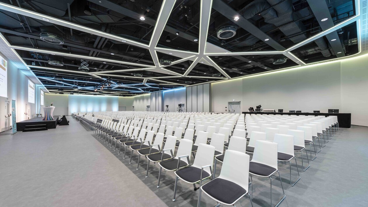 rijen met witte stoelen in een aula