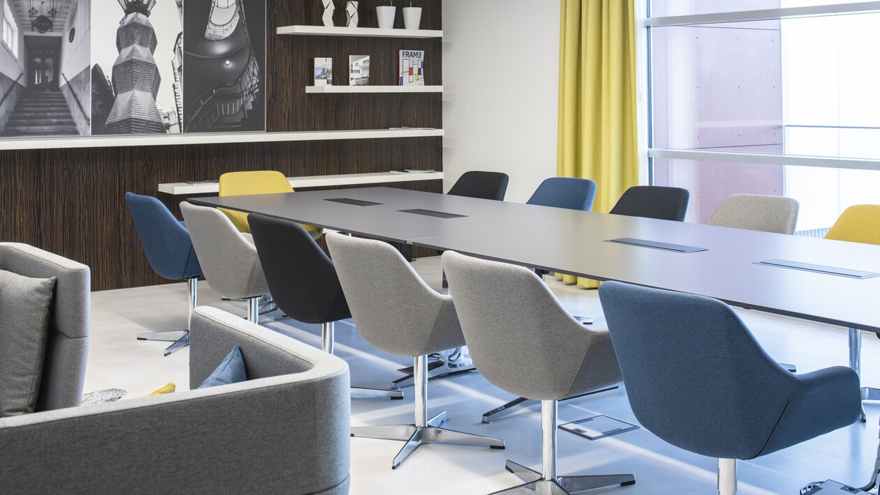 Conferentieruimte met bont gekleurde stoelen en sofa's