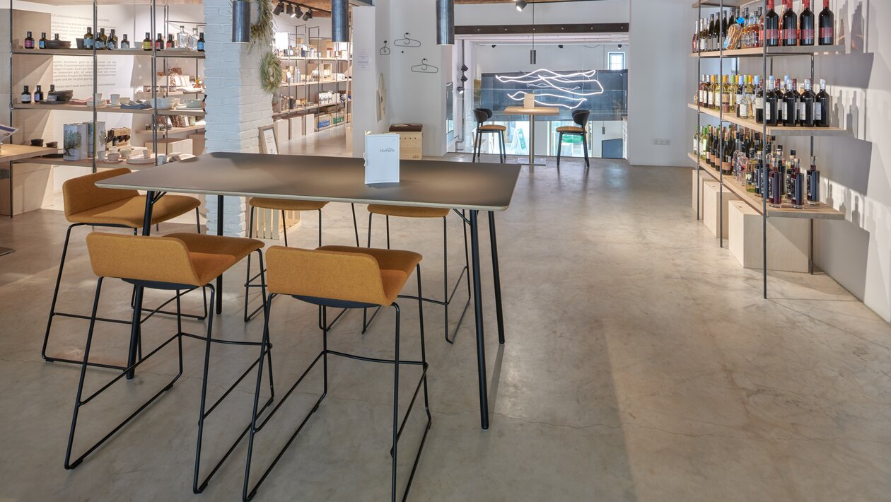 Café avec tabourets de bar et tables hautes | © raumpixel.at