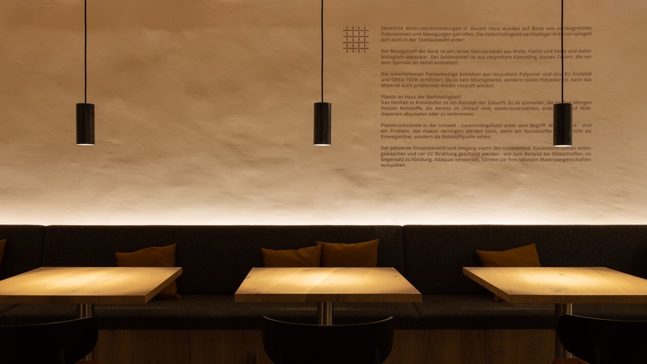 Cafébereich mit Bistrotischen und Stühlen bei Nacht. | © bonpart