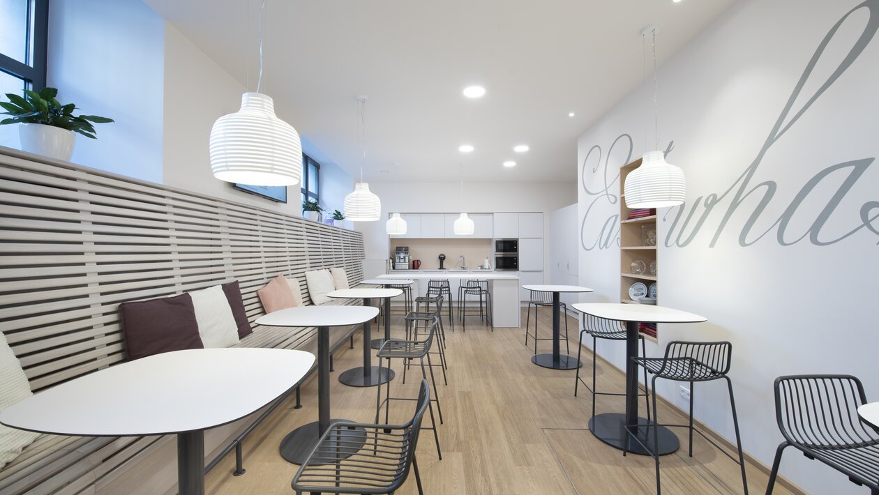 Café with bistro tables and black chairs. | © Saša Dobrovodský