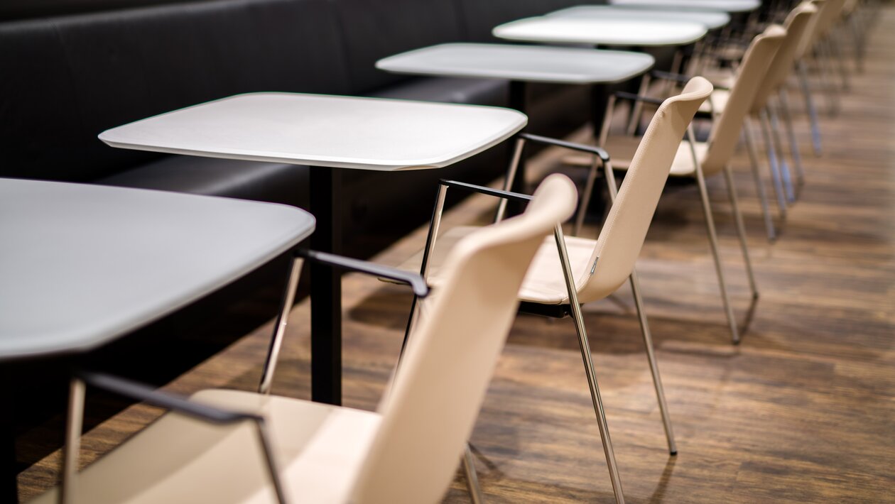 Dark bistro tables with white chairs. | © Gellért Áment