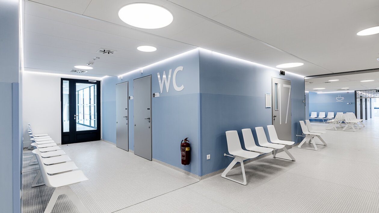 salle d'attente avec murs bleus et canapés d'attente blancs