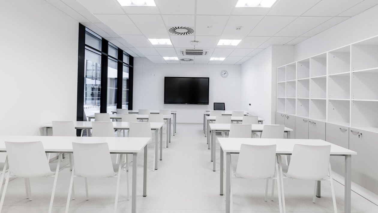 salle de formation avec mobilier blanc et grandes fenêtres