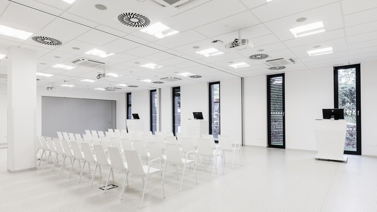 salle de formation avec mobilier blanc et grandes fenêtres