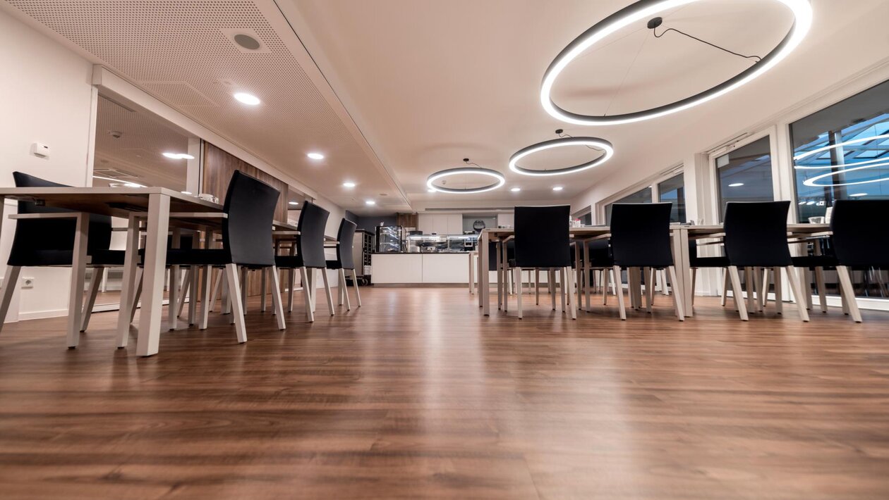 Salle à manger avec parquet et grandes lampes, photographiées d’en bas | © Passauer Wolf