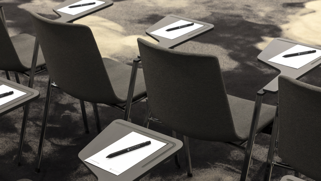 Training classroom with chairs that have a writing tablet.