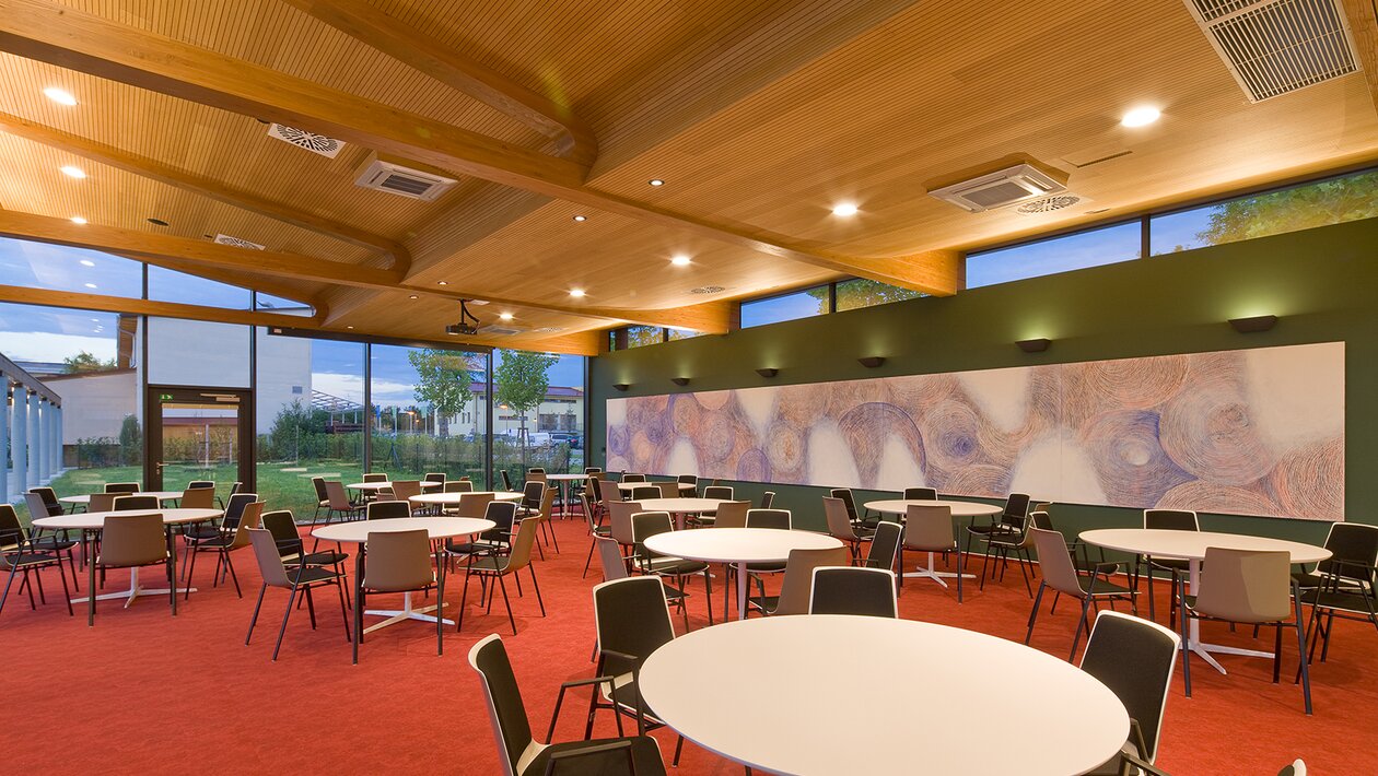 Restaurant with white round tables and chairs.