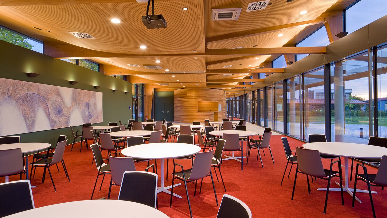 Restaurant with white round tables and chairs. 