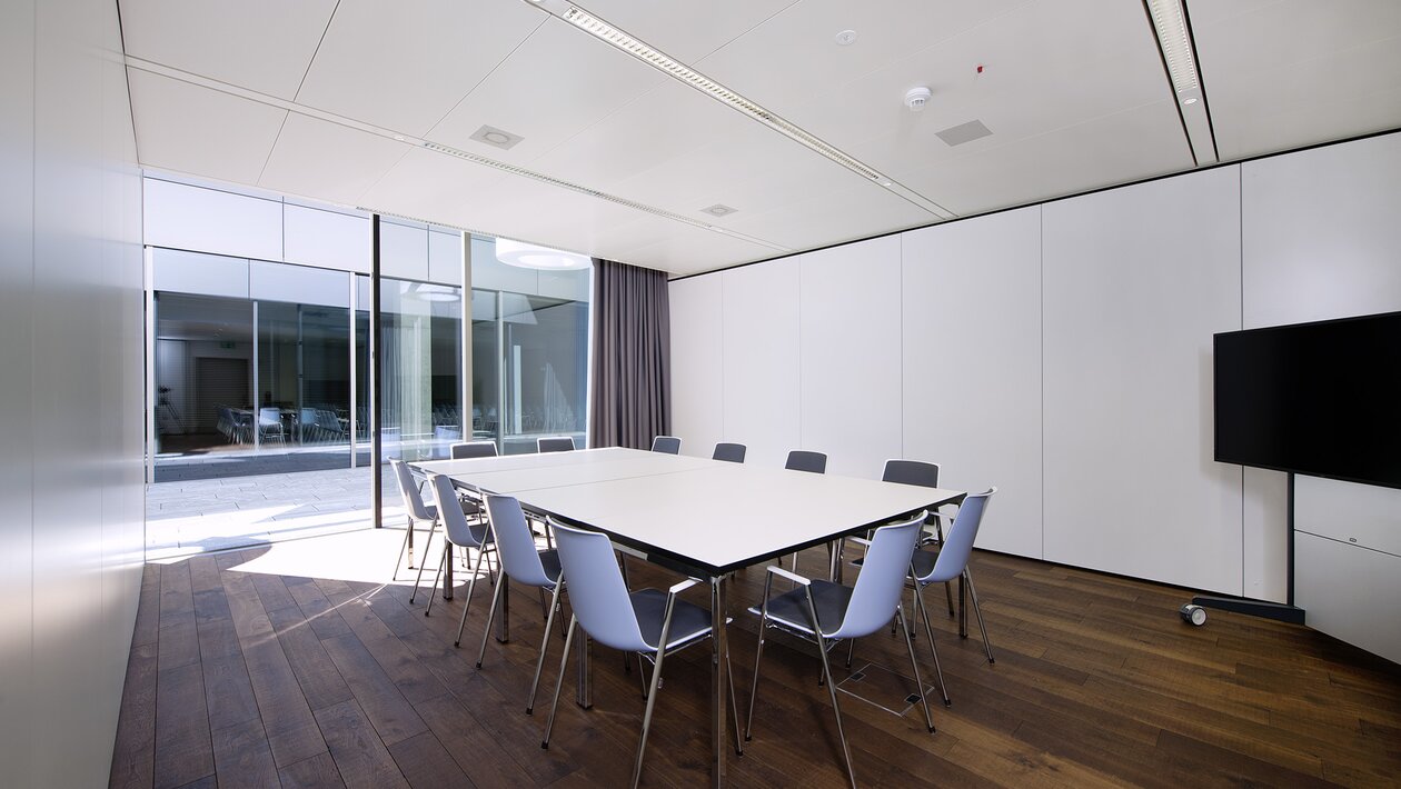 White meeting table with blue chairs. | © Pichler Fotografen, Urs Pichler