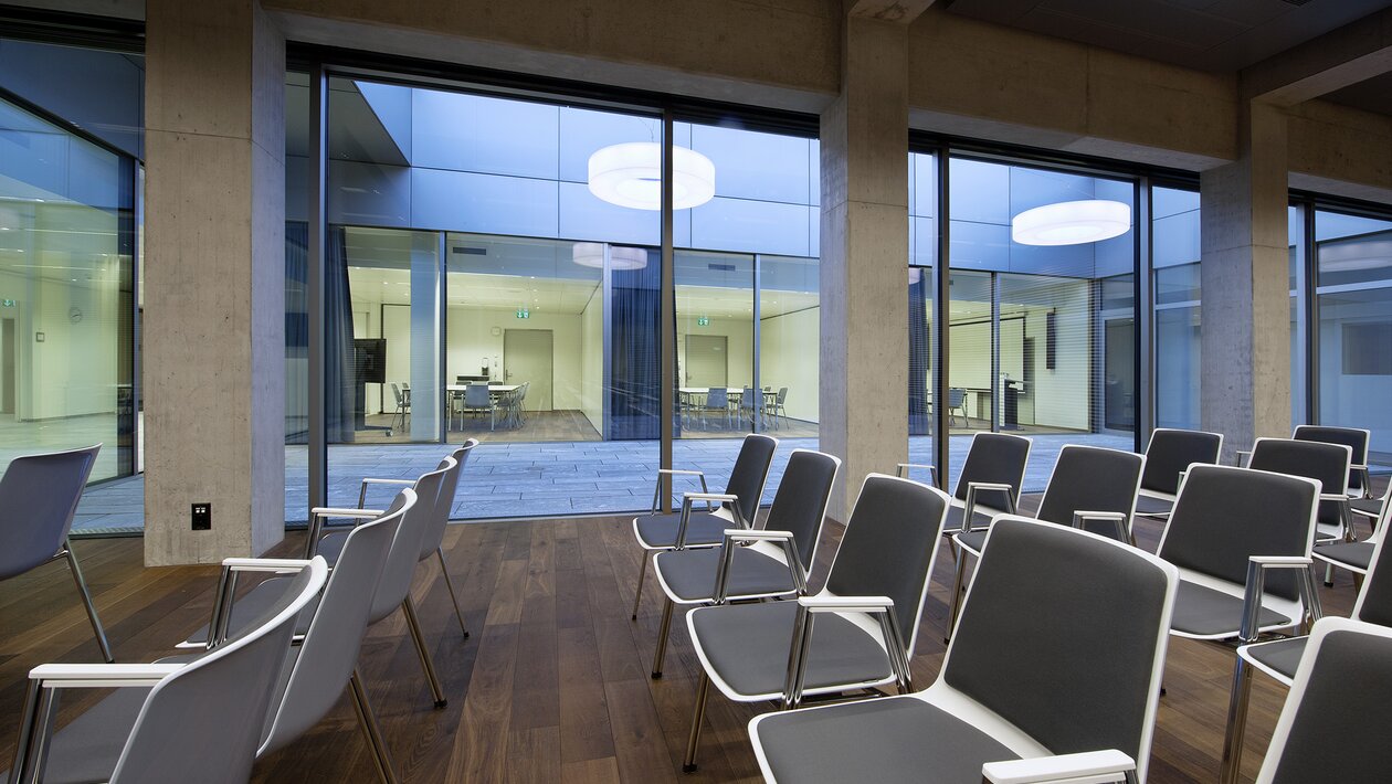 Rows of chairs on a wooden floor.  | © Pichler Fotografen, Urs Pichler