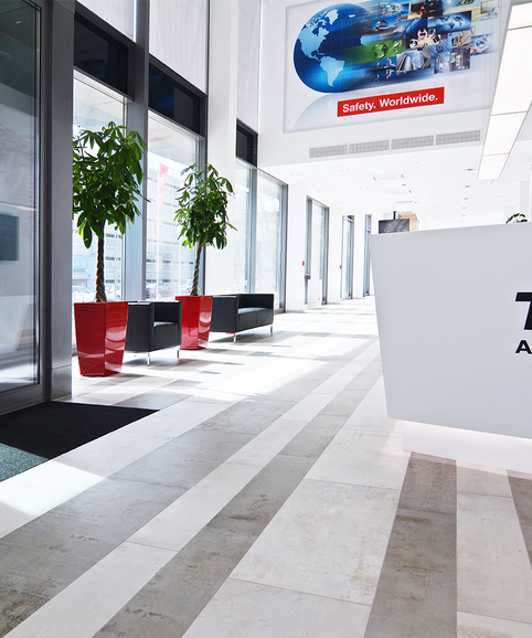 TÜV Austria Heller Empfangsbereich mit roten Elementen.