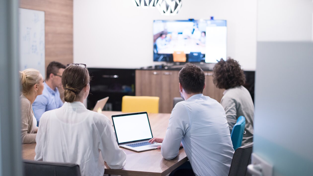 Personen sitzen in einem Hybrid-Meeting.  | © Shutterstock