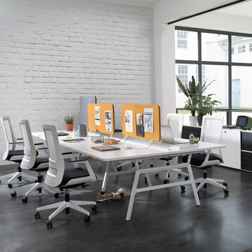 Workbench in a small office with white swivel chairs.