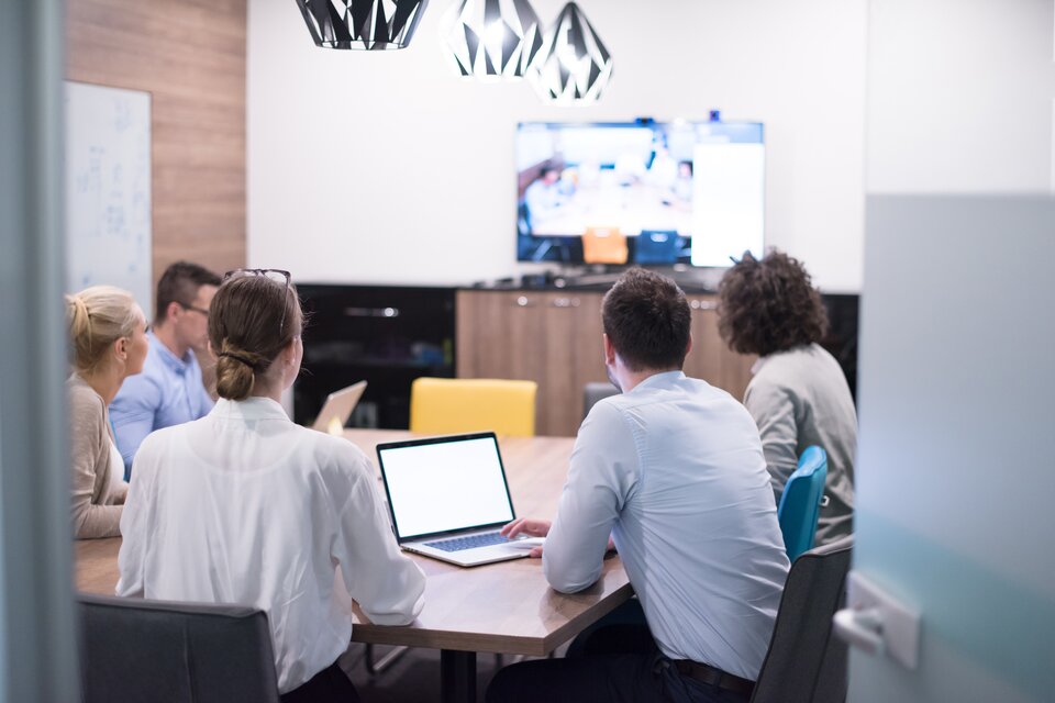 Personen sitzen in einem Hybrid-Meeting.  | © Shutterstock
