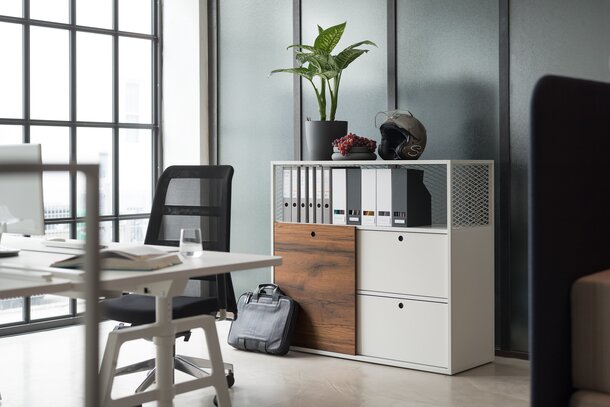 White cabinet system behind a white desk with a black swivel chair.