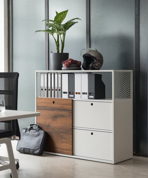 White cabinet system behind a white desk with a black swivel chair.