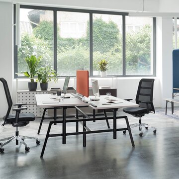 Office desk with black swivel chairs in a light and modern office.