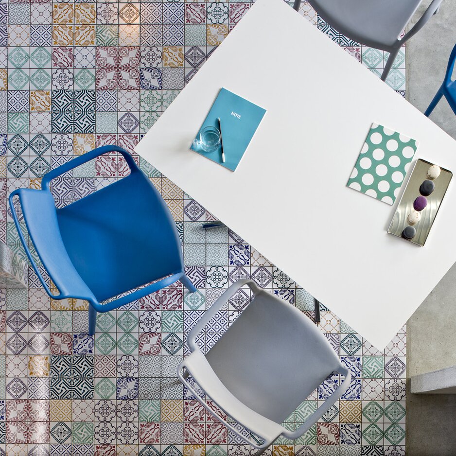 Colourful chairs at a white table.