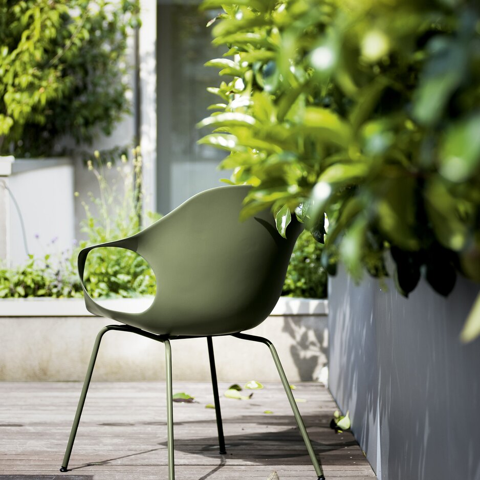 Grüner Outdoor-Stuhl auf einer Terrasse. 