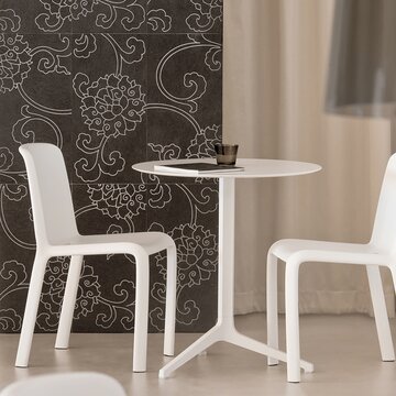Weißer Tisch mit zwei weißen Stühlen. 