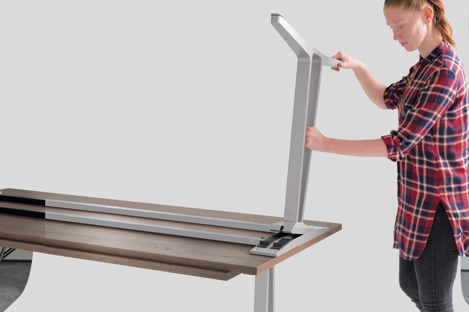 skill table_système-pieds flexibles une dame qui déplace des pieds de table modulaires