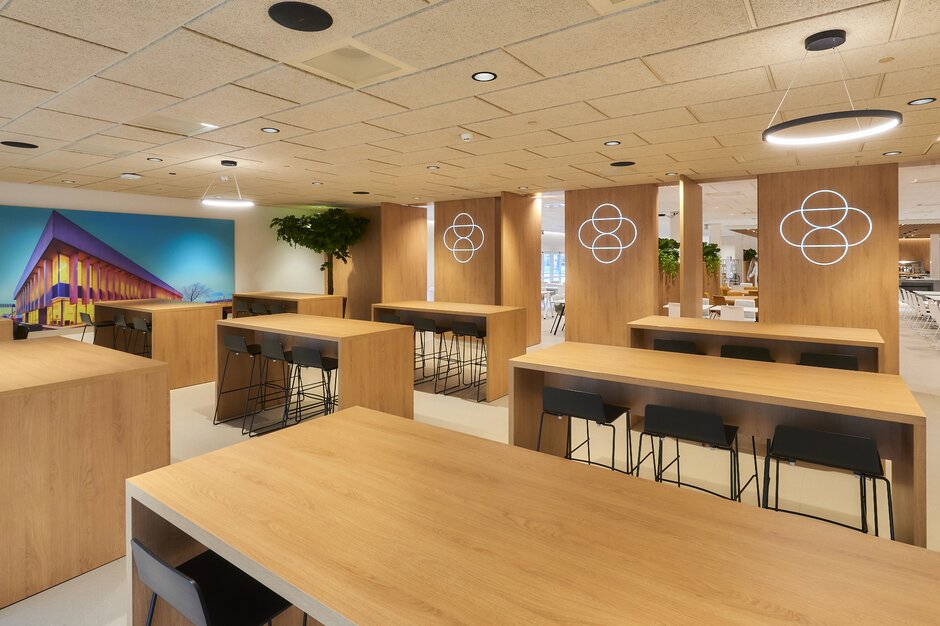 Tables hautes en bois avec tabourets dans un cantine | © Michel Campfens